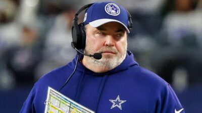 Mike McCarthy in Cowboys gear and headset on sidelines