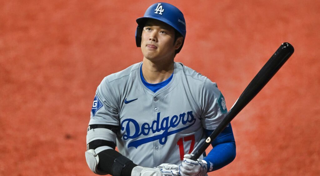 Shohei Ohtani in Dodgers uniform while holding a bat.