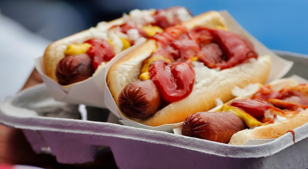 Hot dogs on a tray at a baseball game. The Miami Marlins will be offering all you can eat tickets at their ballpark this season.