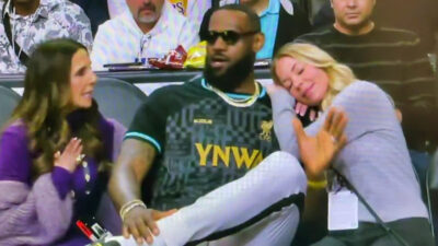 Jeanie Buss resting on LeBron James' shoulder