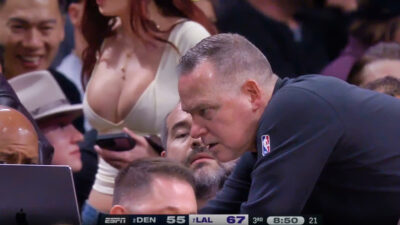 female fan in Mike Malone's background at Nuggets-Lakers game