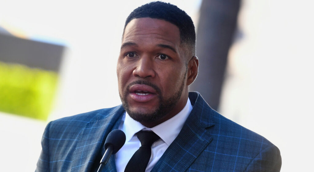 Michael Strahan speaking into a mic