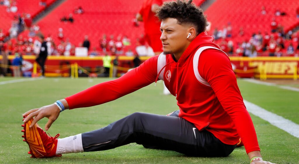 Patrick Mahomes sitting on ground streatching