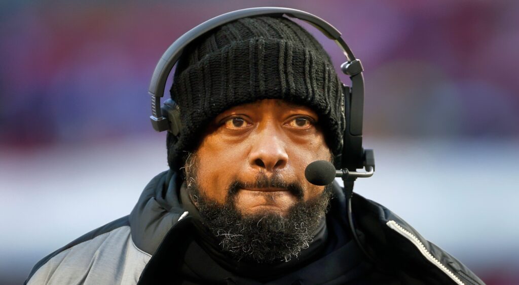 Mike Tomlin with headset on and jacket while on sidelines.