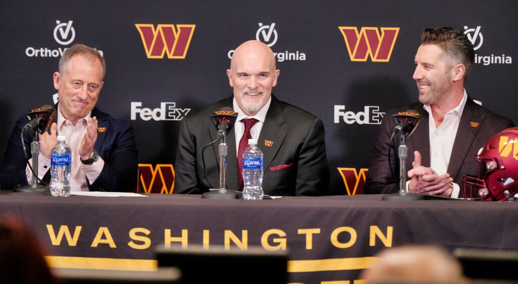 Josh Harris, Dan Quinn and Adam Peters sitting at a table during the Washington Commanders' press conference.