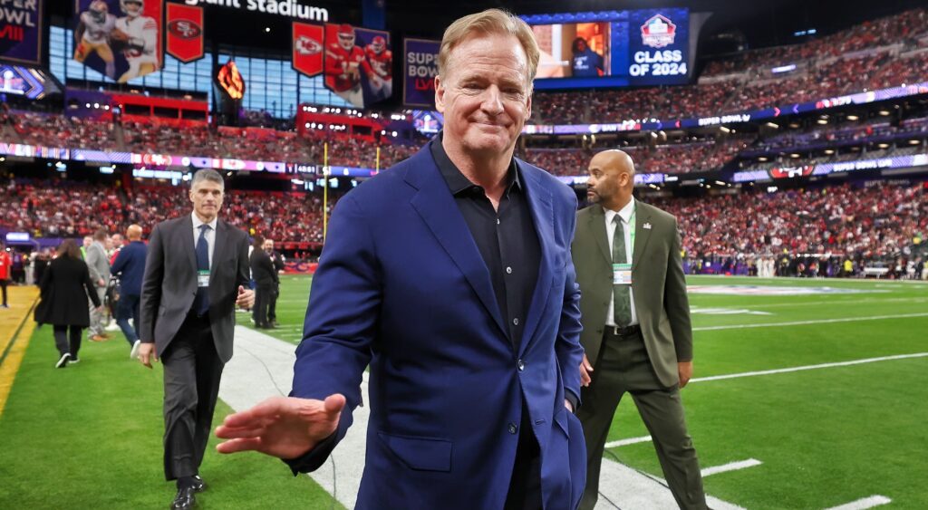 Roger Goodell walks off the field at an NFL game.