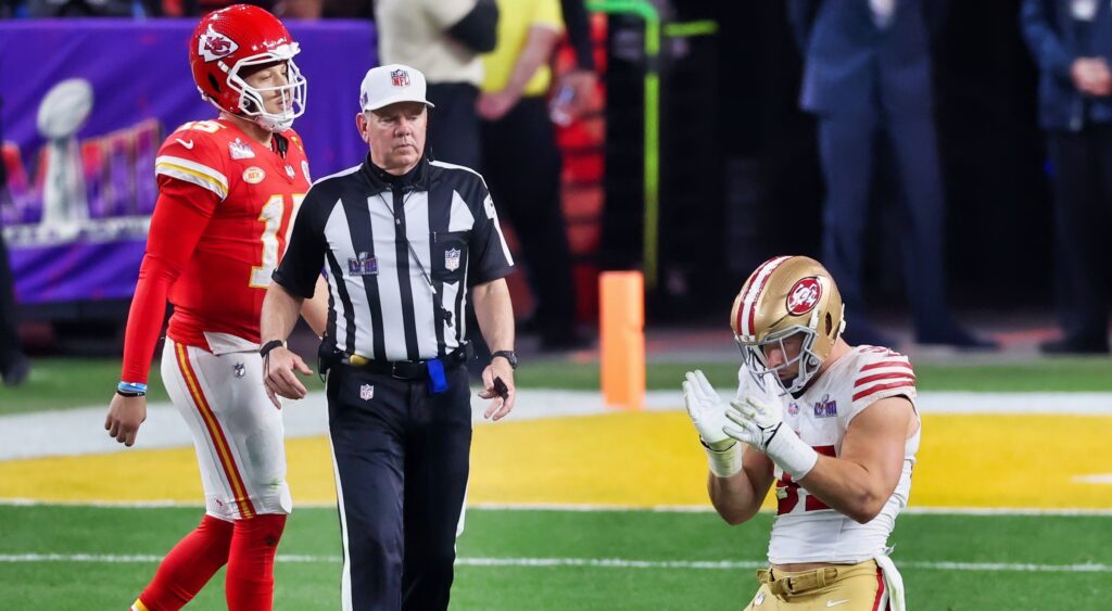 Chiefs' Patrick Mahomes walks and San Francisco 49ers' Nick Bosa kneels on the field after a play at Super Bowl 58.