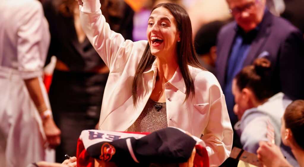 Caitlin Clark waving while at the WNBA Draft