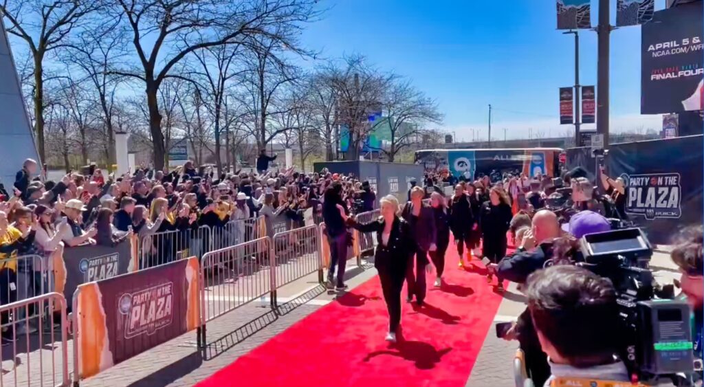 The Iowa Hawkeyes walk down the red carpet after arriving at the national title game.