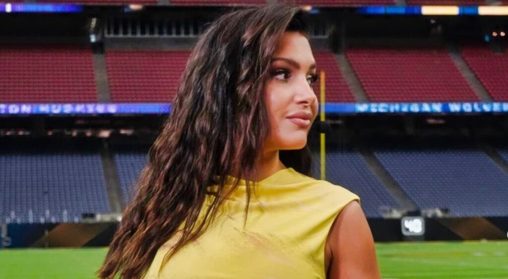 Molly Qerim poses on the field before a college football game.