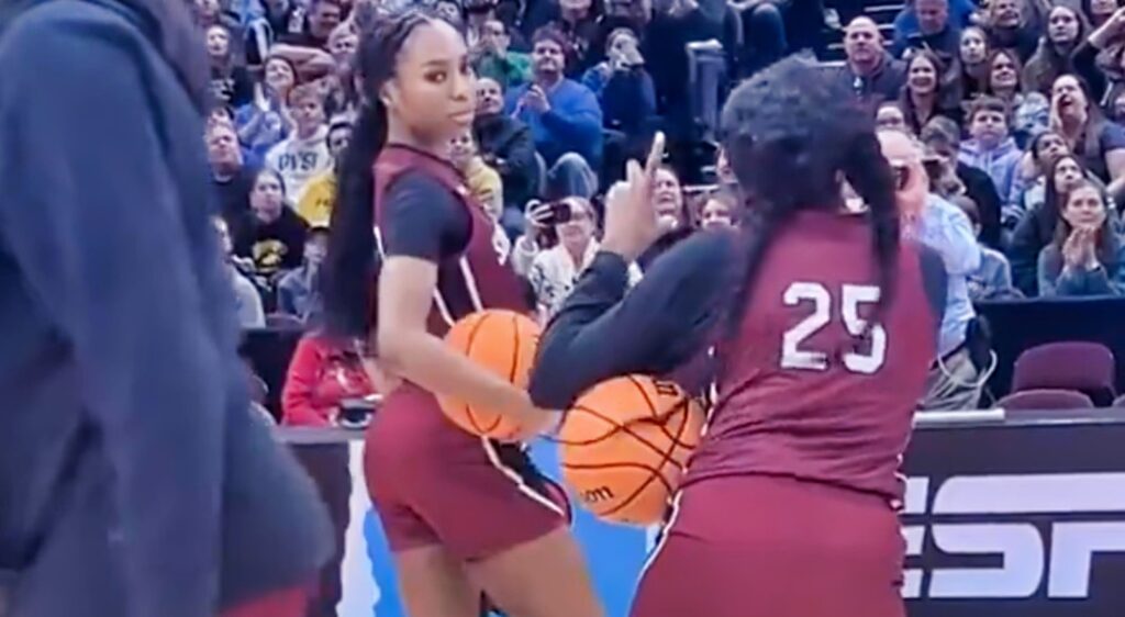 South Carolina Gamecocks player Raven Johnson pretends to take photos of a teammate on the court.