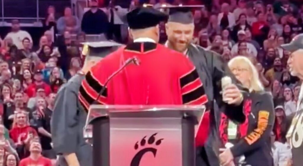 Travis Kelce receiving his diploma during a ceremony.