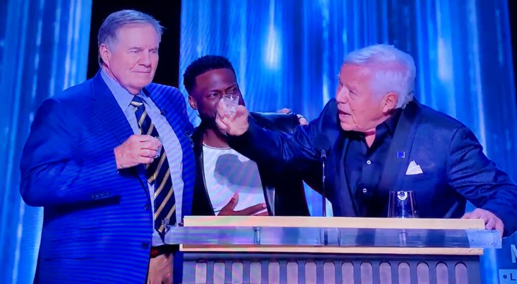 Bill Belichick and Robert Kraft have a shot at Tom Brady's roast while Kevin Hart looks on.