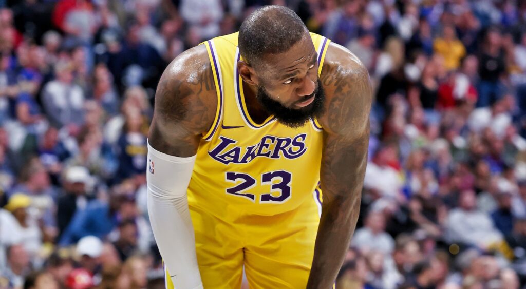 LeBron James bends over with his hands on his knees during a game.