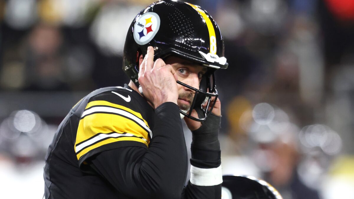 Aaron Rodgers with hands on helmet