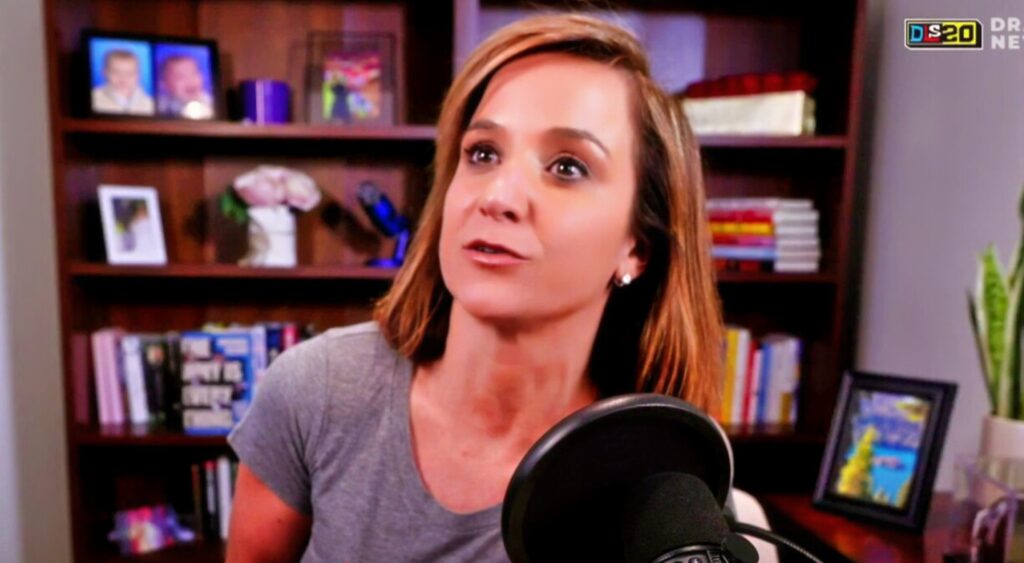 Dianna Russini on a podcast in a gray shirt.