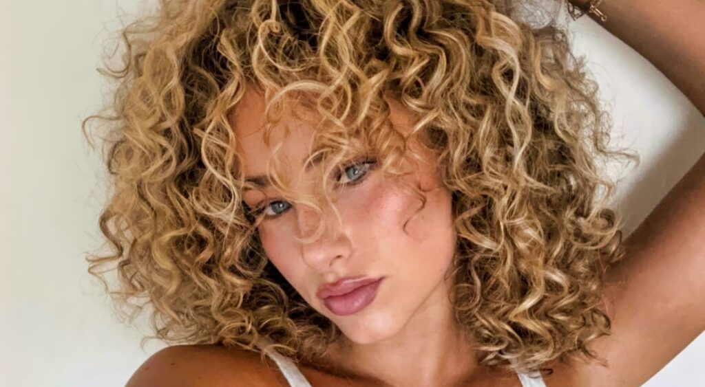 Gia Duddy posing with curly hair