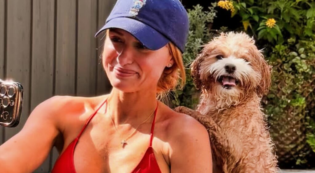 Jane Slater posing in a red bikini with her dog.