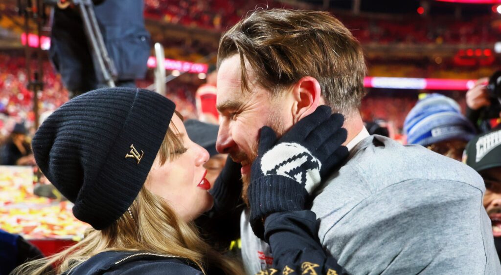 Recording artist Taylor Swift  and Kansas City Chiefs tight end Travis Kelce kissing each other.
