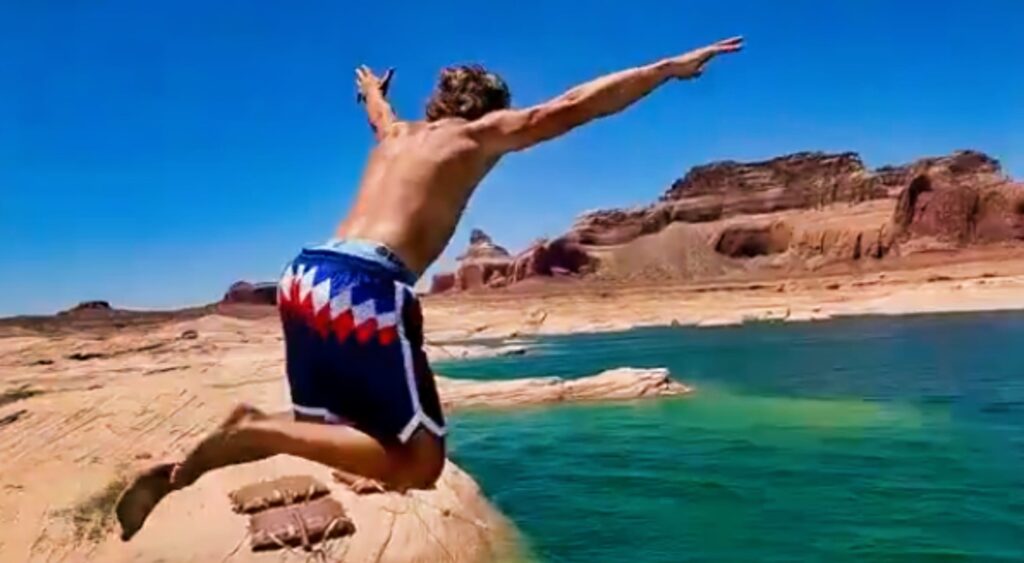 Jaxson Dart jumping off of a boat.