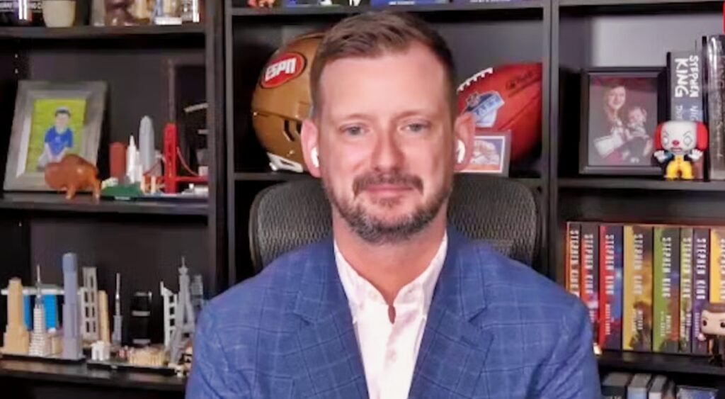 Matt Miller sitting in front of books.