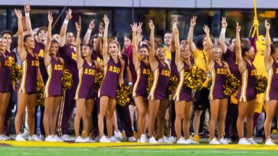 Arizona State Sun Devils cheerleaders standing on the sidelines.