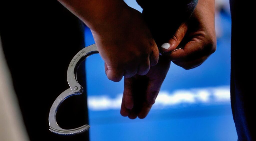 Handcuffs being placed on a person.