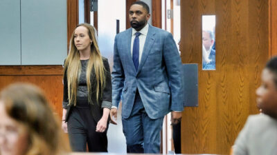 Sherrone Moore and his wife Kelli entering court.